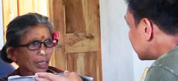 A Hindu lady trying out reading glasses at a medical clinic