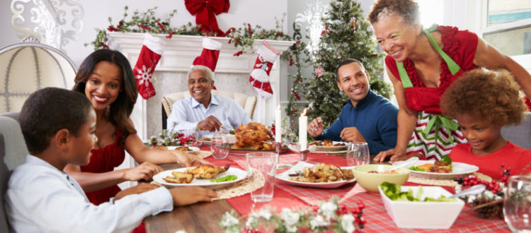 Family With Grandparents Enjoying Christmas Meal At Table