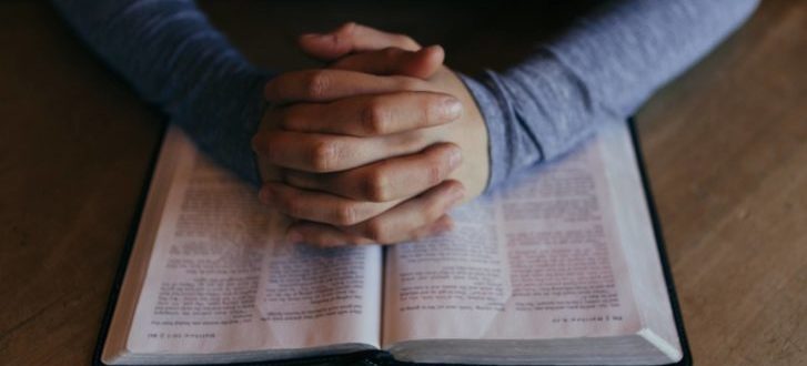 Praying hands on Bible