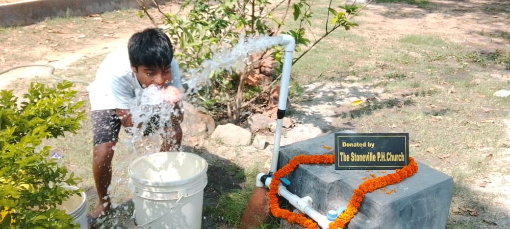 Boy drinking water from water source